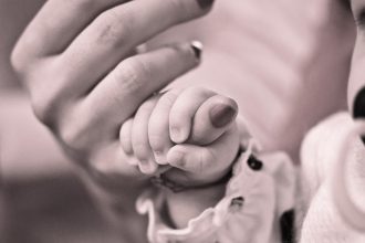 Baby greift Hand