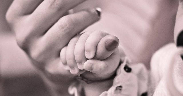 Baby greift Hand
